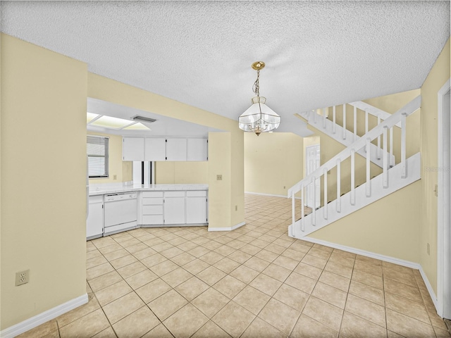 kitchen with light countertops, visible vents, white cabinets, dishwasher, and baseboards