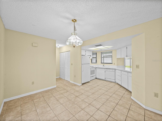 kitchen featuring white appliances, light tile patterned floors, light countertops, white cabinetry, and a sink