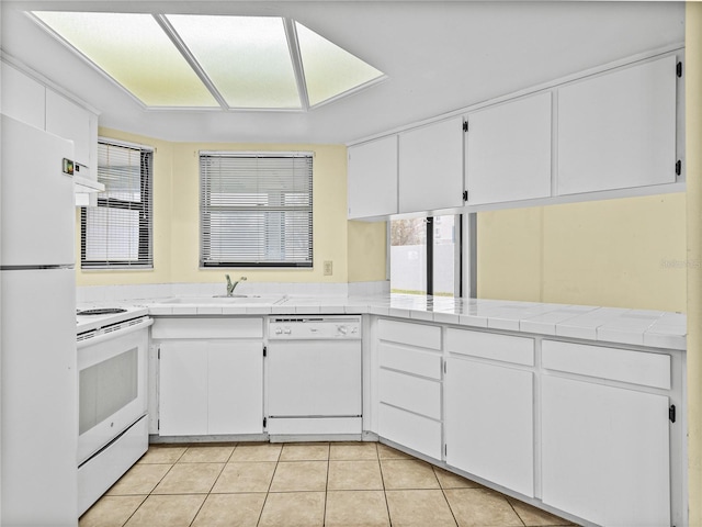 kitchen featuring white appliances, white cabinetry, and tile counters