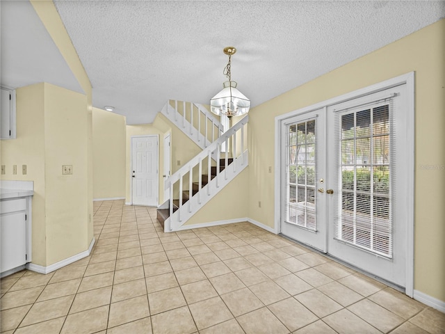 interior space with french doors, stairway, light tile patterned flooring, and a notable chandelier