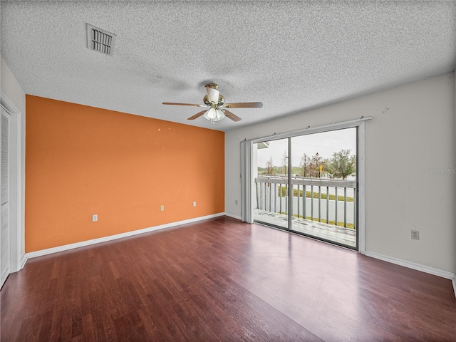 unfurnished room featuring a ceiling fan, visible vents, baseboards, and wood finished floors