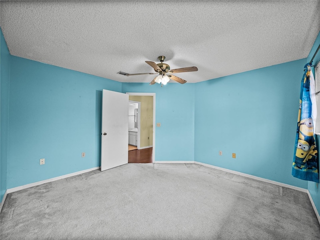 unfurnished bedroom featuring a textured ceiling, carpet, visible vents, and baseboards