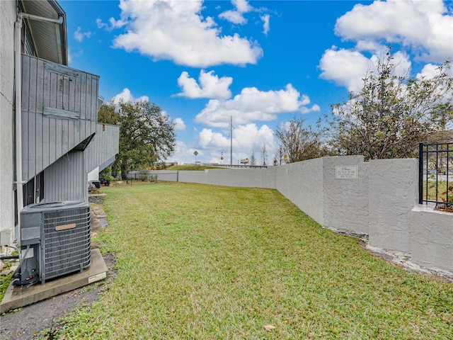 view of yard with a fenced backyard and central air condition unit