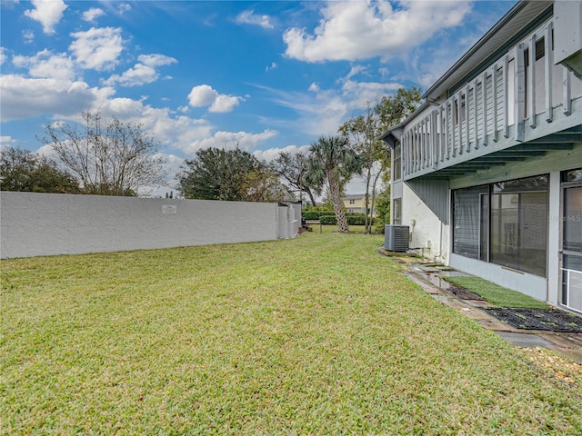 view of yard with central AC unit and fence