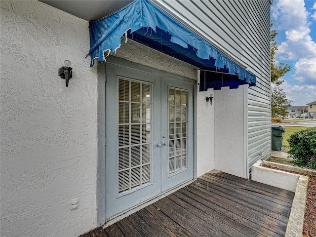 view of exterior entry featuring stucco siding and french doors