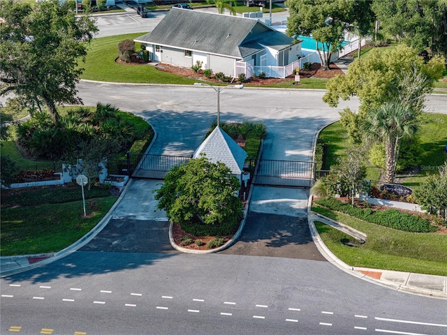 view of road featuring curbs, a gated entry, and a gate