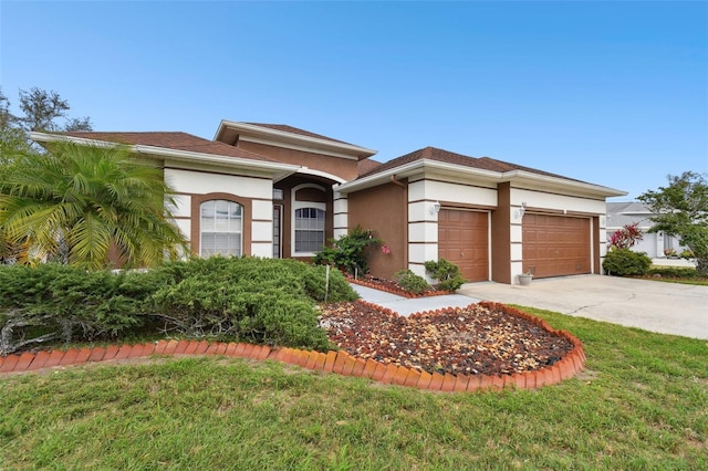 view of front facade with driveway, a garage, a front lawn, and stucco siding