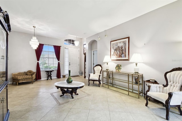 living area featuring baseboards, arched walkways, and light tile patterned flooring