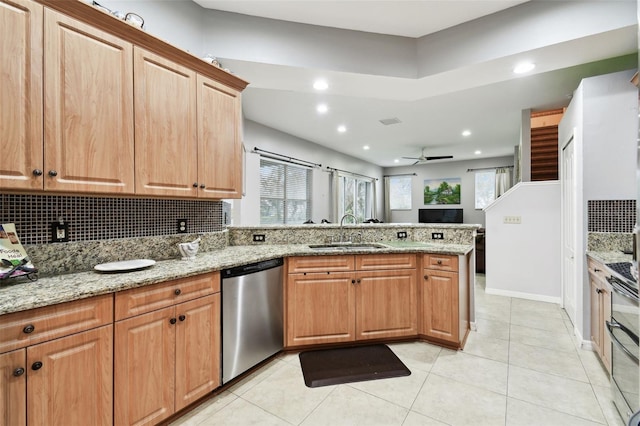 kitchen with a peninsula, a sink, appliances with stainless steel finishes, backsplash, and light stone countertops