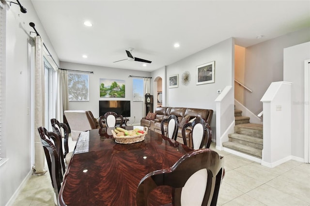 dining area with arched walkways, light tile patterned floors, recessed lighting, and stairs