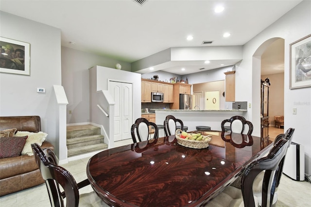 dining room featuring recessed lighting, visible vents, arched walkways, stairway, and light tile patterned flooring