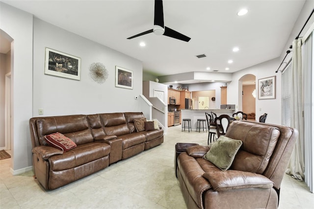 living area featuring arched walkways, a ceiling fan, and recessed lighting