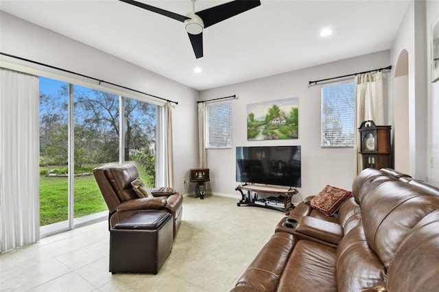 living area with ceiling fan, arched walkways, baseboards, and recessed lighting