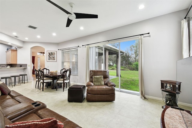 living area with visible vents, arched walkways, baseboards, ceiling fan, and recessed lighting