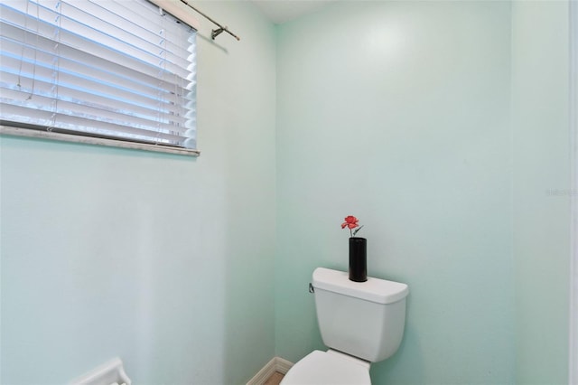 bathroom featuring toilet and baseboards