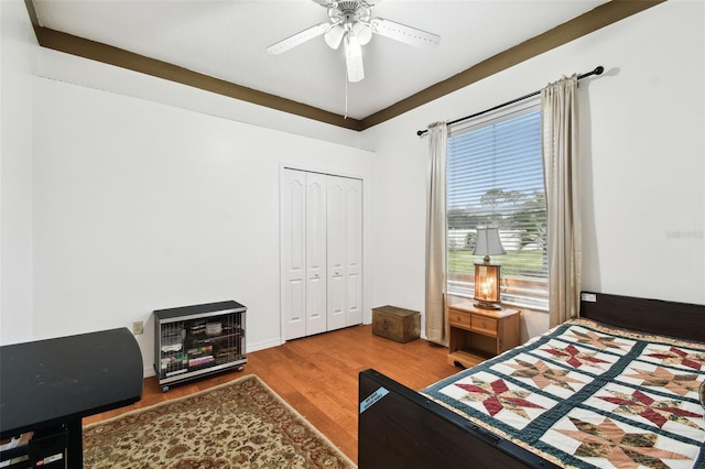 bedroom with a closet, a ceiling fan, and wood finished floors