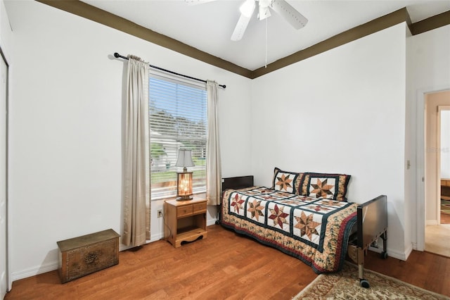 bedroom with ceiling fan, wood finished floors, and baseboards