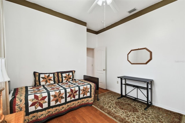 bedroom with visible vents, ceiling fan, baseboards, and wood finished floors