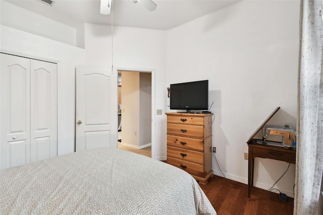 bedroom featuring dark wood-style floors, a closet, ceiling fan, and baseboards