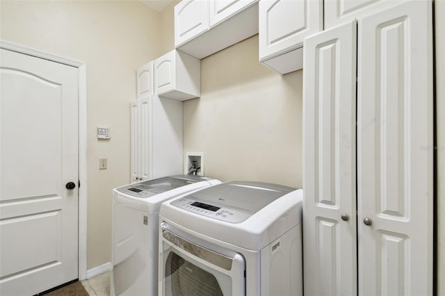 clothes washing area with independent washer and dryer, cabinet space, and baseboards