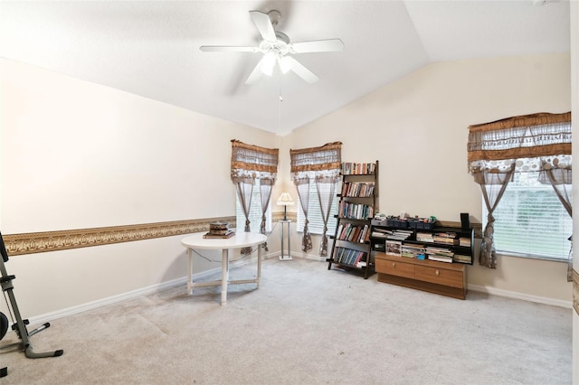 interior space with light colored carpet, vaulted ceiling, baseboards, and ceiling fan