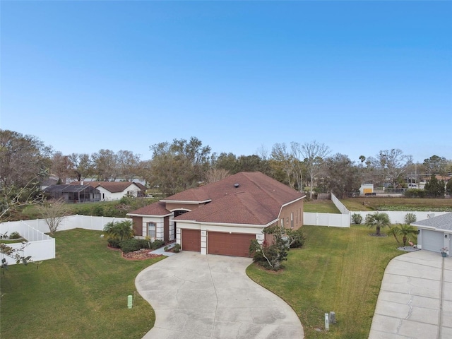 view of front facade with a garage, fence, driveway, and a front lawn