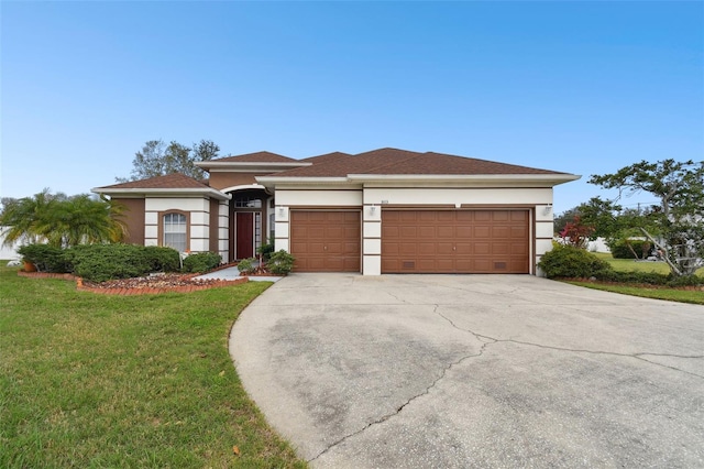 view of front of house featuring driveway, a front yard, a garage, and stucco siding