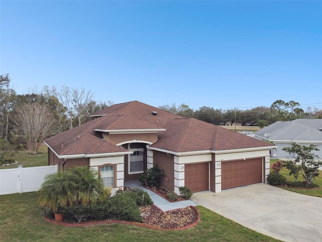 view of front of house featuring a garage, concrete driveway, fence, a front lawn, and stucco siding