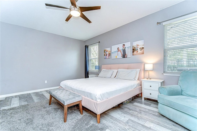 bedroom featuring ceiling fan, baseboards, and wood finished floors