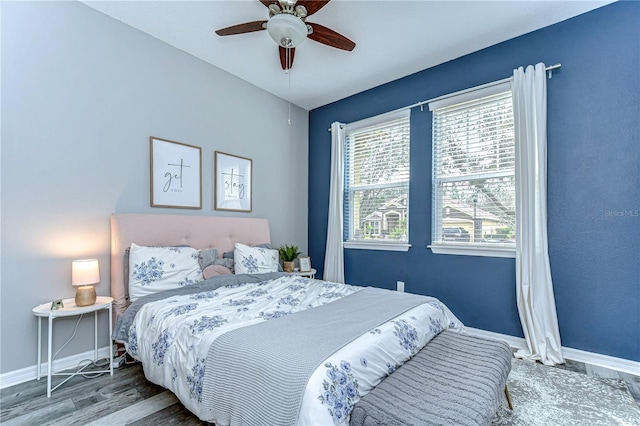 bedroom with a ceiling fan, baseboards, and wood finished floors