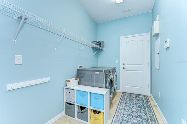 clothes washing area featuring laundry area, washer and clothes dryer, and baseboards