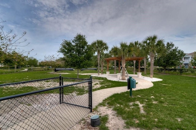 view of property's community featuring a gate, a lawn, and fence