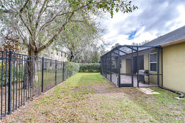 view of yard featuring glass enclosure, a fenced backyard, and a patio area