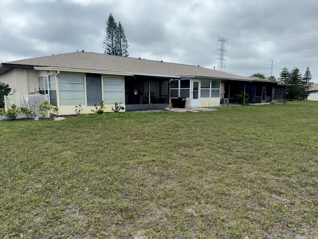 rear view of property with a yard and a sunroom