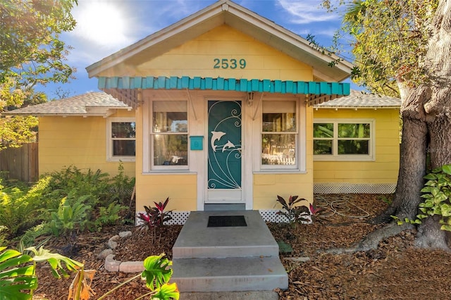 entrance to property with a shingled roof