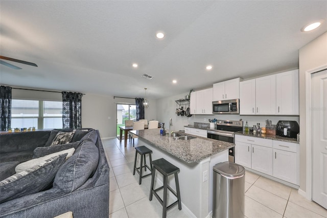 kitchen with white cabinetry, a center island with sink, appliances with stainless steel finishes, and a sink