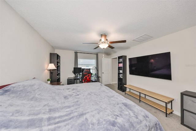 bedroom with carpet, visible vents, ceiling fan, and a textured ceiling