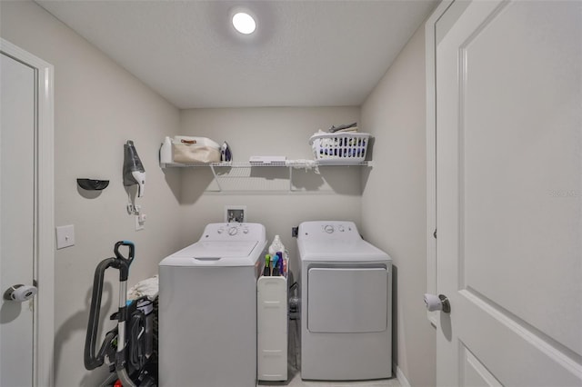 clothes washing area featuring washer and dryer, laundry area, and a textured ceiling