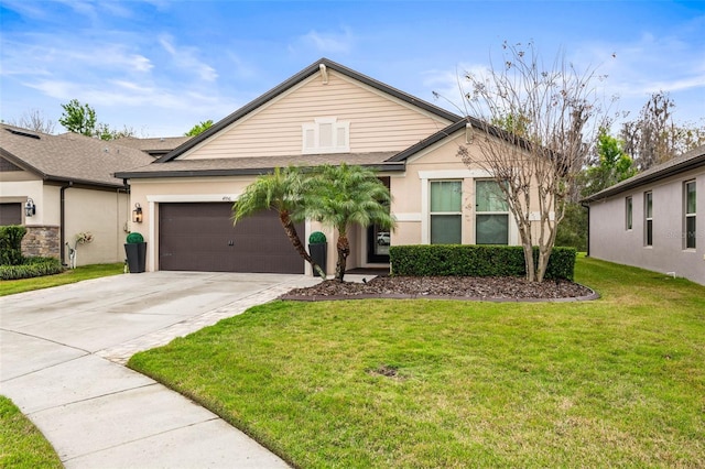 single story home with a garage, concrete driveway, a front yard, and stucco siding