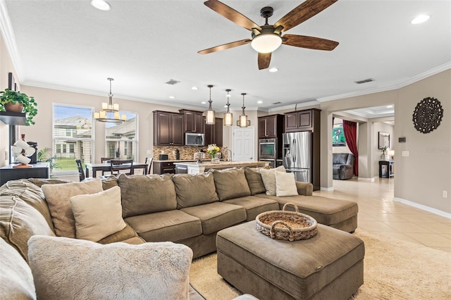 living room with light tile patterned floors, baseboards, visible vents, and crown molding