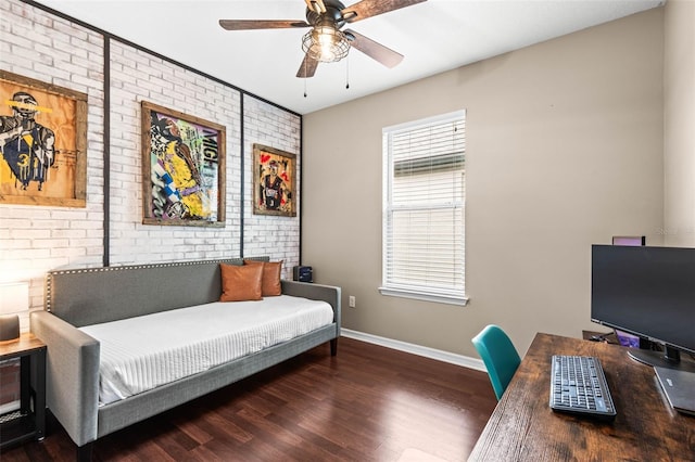 bedroom featuring ceiling fan, brick wall, dark wood-style flooring, and baseboards