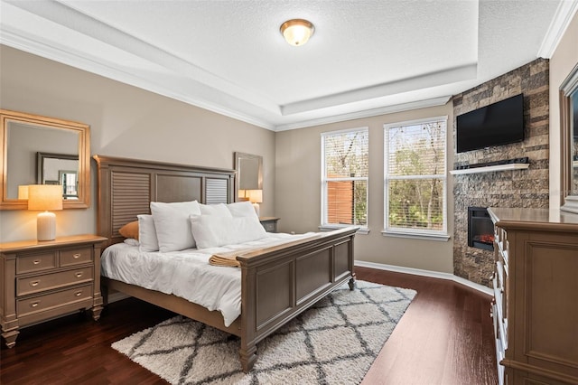 bedroom featuring dark wood-type flooring, a fireplace, a textured ceiling, and baseboards