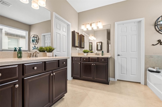 bathroom featuring visible vents, a sink, and tile patterned floors