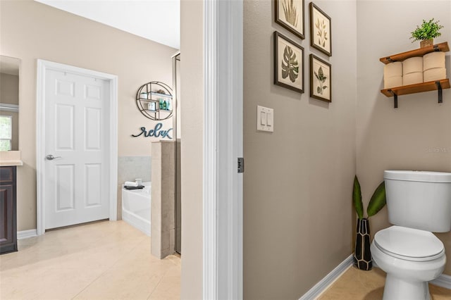 bathroom with a bath, tile patterned flooring, toilet, and baseboards