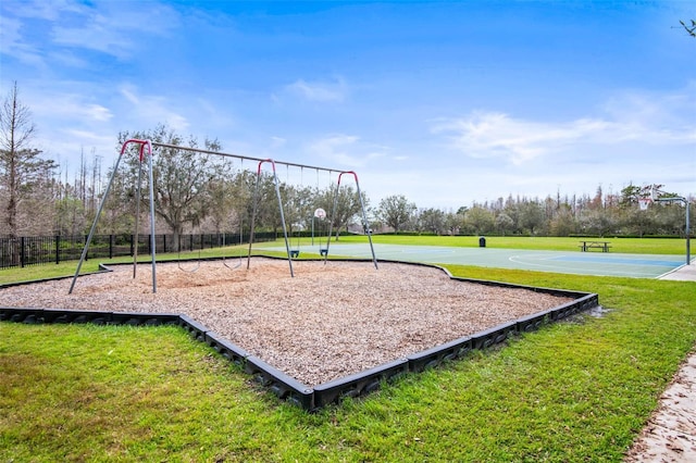 surrounding community featuring community basketball court, fence, and a lawn