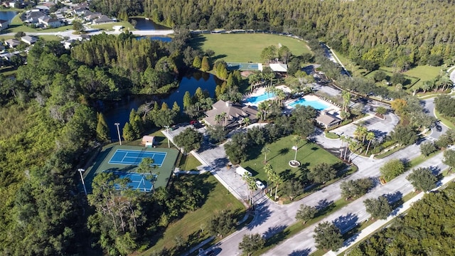 birds eye view of property featuring a forest view and a water view