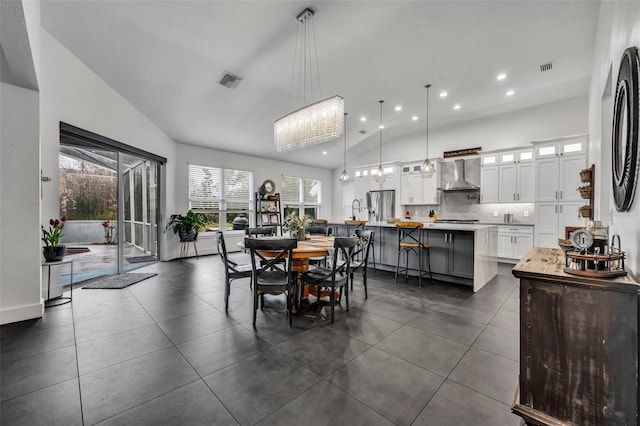 dining space featuring high vaulted ceiling, dark tile patterned floors, visible vents, and recessed lighting