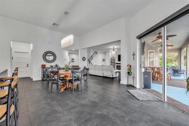 dining room featuring baseboards, a fireplace, visible vents, and a ceiling fan