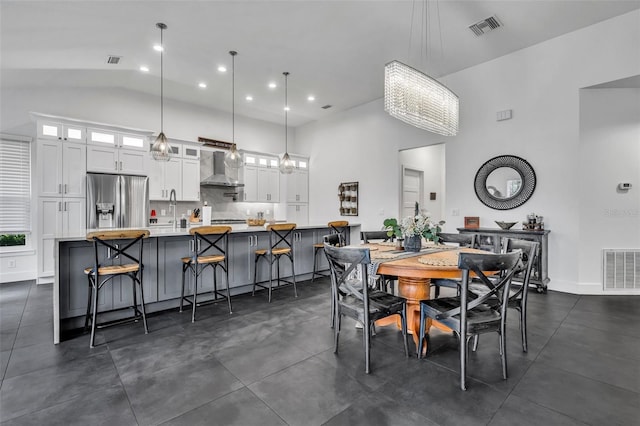 dining room featuring high vaulted ceiling and visible vents