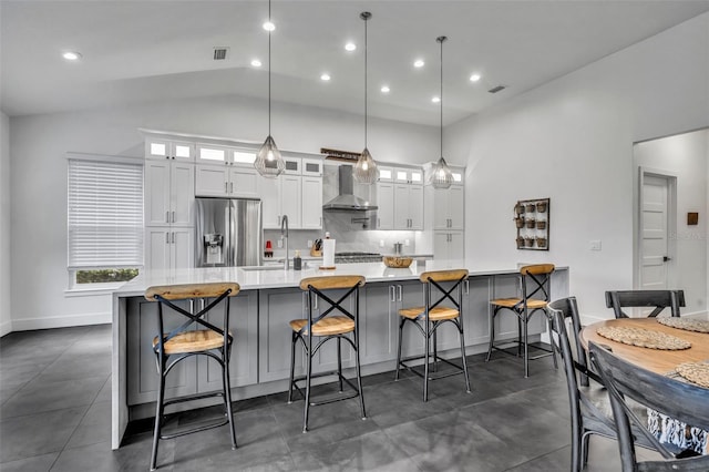 kitchen featuring glass insert cabinets, pendant lighting, light countertops, white cabinetry, and stainless steel refrigerator with ice dispenser